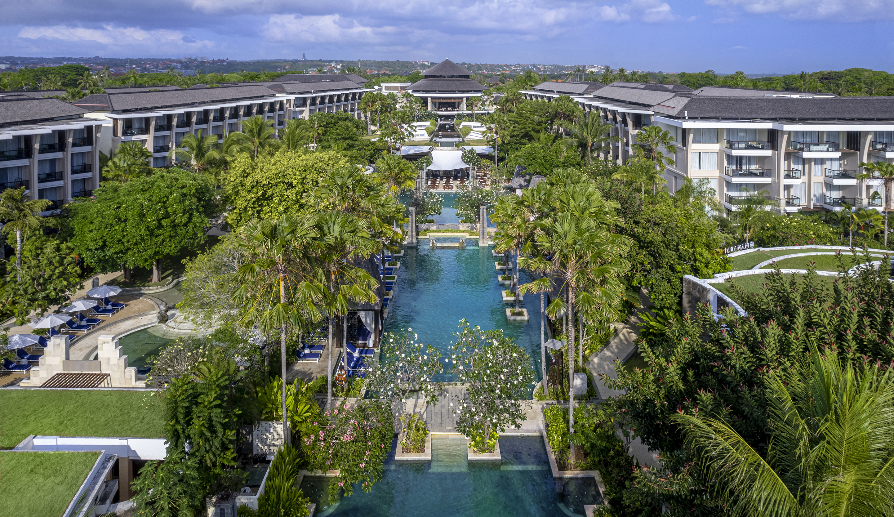 Aerial view of Sofitel Bali Nusa Dua Beach Resort with long central lagoon pool and gardens by the beach