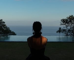 woman sitting on field during daytime uluwatu