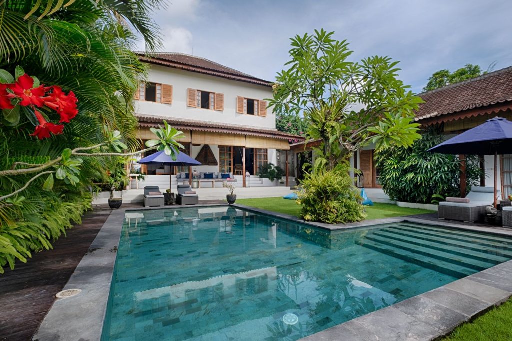 Villa Maya Berawa tropical villa with large pool frangipani tree green lawn and poolside loungers