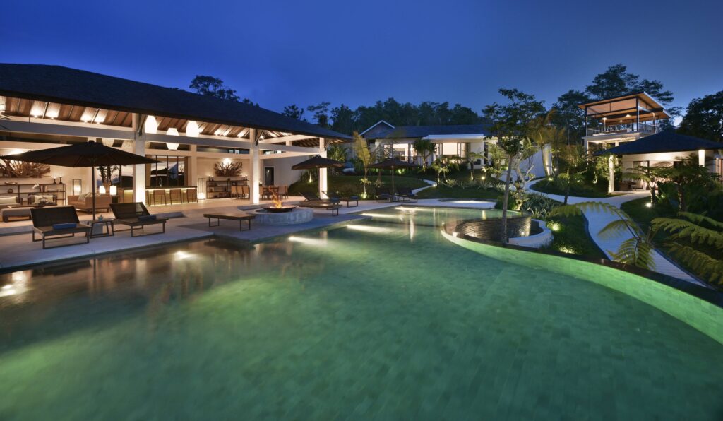 Luxury Bali resort with an illuminated swimming pool at dusk