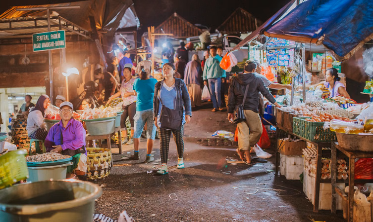 Crowded Nusa Dua night market in Bali with food stalls bright lights and local people shopping in the evening