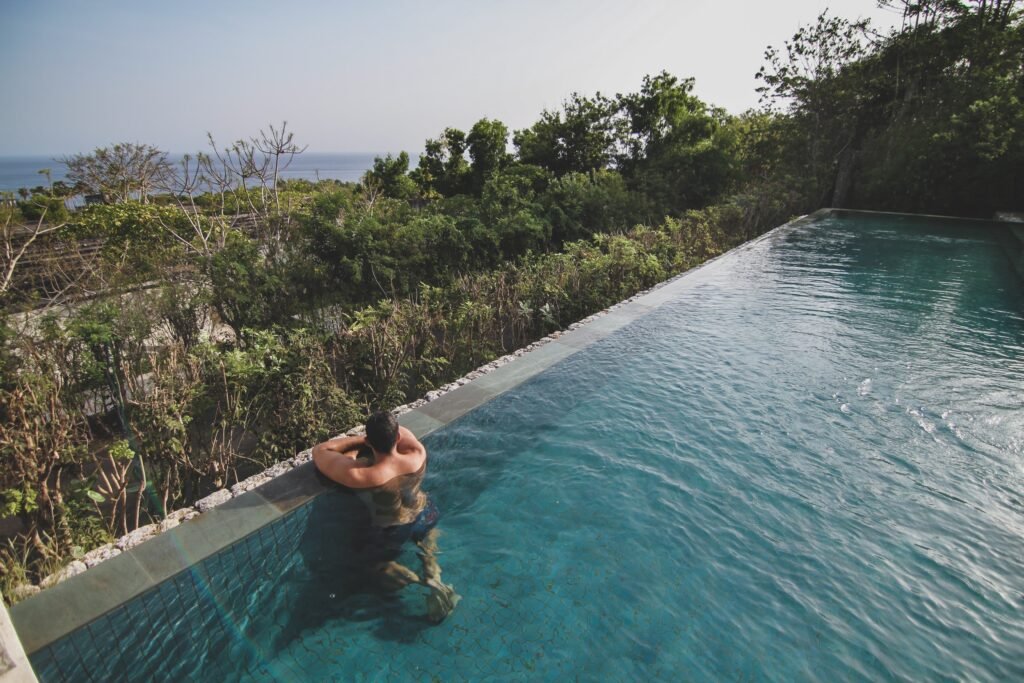 Infinity pool overlooking tropical forest and the ocean in Bali
