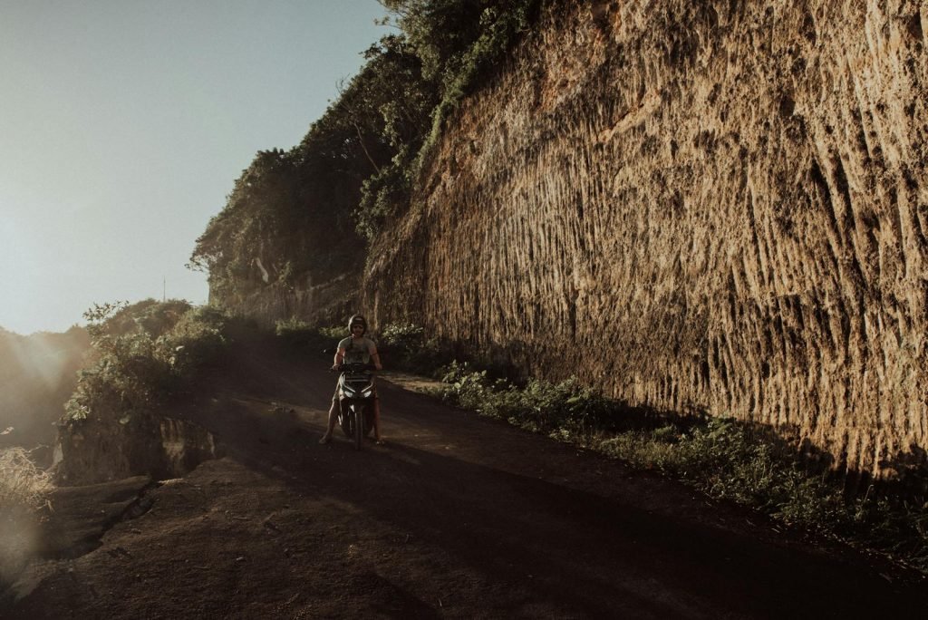 Man Riding a Scooter on Dirt Road Uluwatu