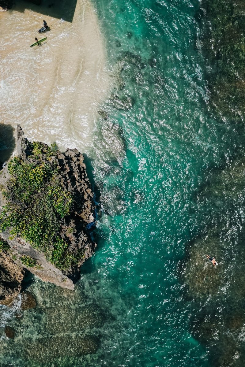 a group of people swimming in a body of water uluwatu