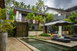 A pool in front of a house surrounded by greenery bali villa