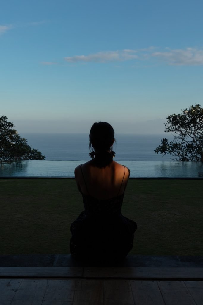 woman sitting on field during daytime uluwatu