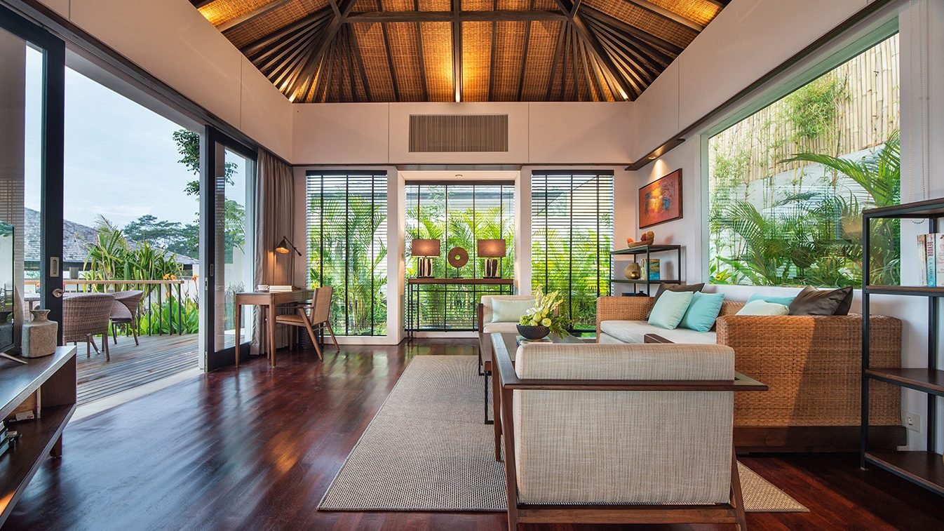 Ruang tamu Alta Vista Mountain Villa Bali dengan sofa, jendela besar, dan akses balkon