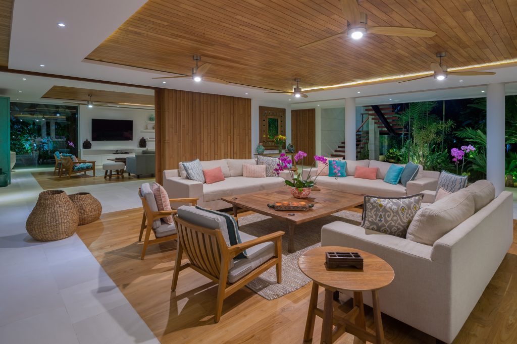 Villa Zambala Canggu spacious open living room with sofas wooden ceiling and garden view at night