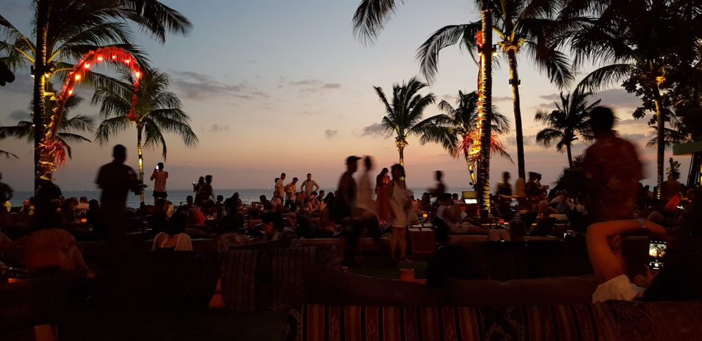 People relaxing on Seminyak Beach at sunset in Bali