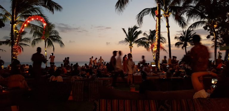 People relaxing on Seminyak Beach at sunset in Bali
