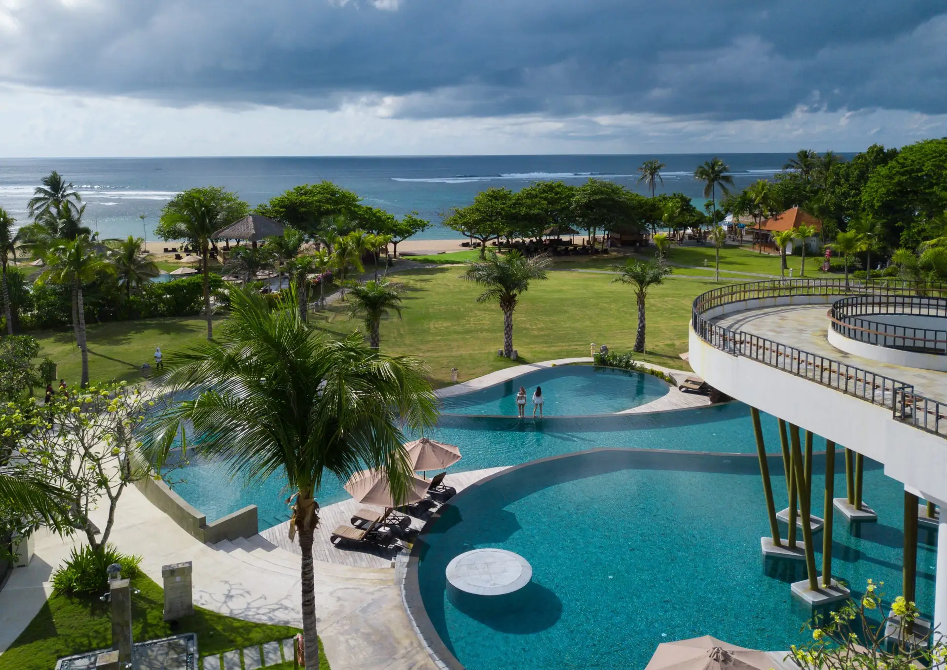 Oceanfront pool and tropical lawn at Merusaka Nusa Dua overlooking Mengiat Beach in Bali